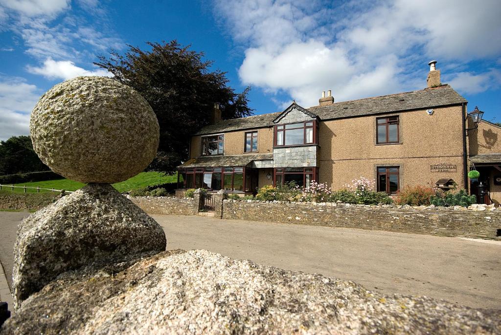 a statue of a person sitting on a rock in front of a house at Tregondale Manor Farm in Liskeard