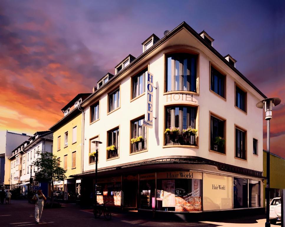 ein großes weißes Gebäude mit einem Hotel an einer Straße in der Unterkunft Hotel Heymann in Kaiserslautern