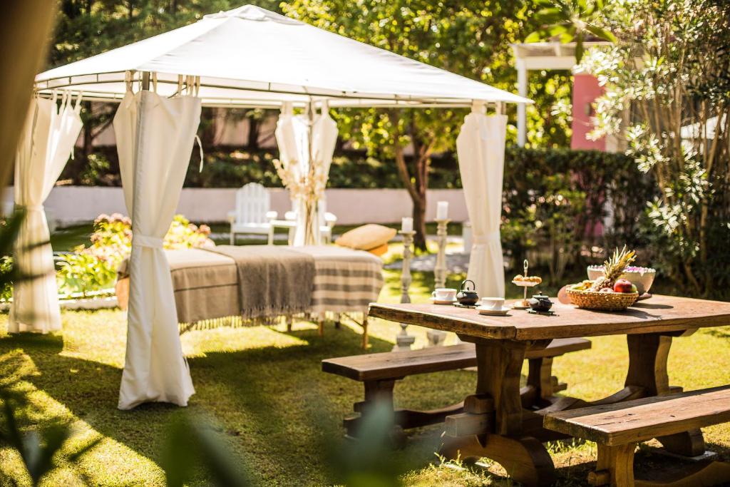 a gazebo with a bed and a picnic table at Mandraki Village Boutique Hotel in Koukounaries