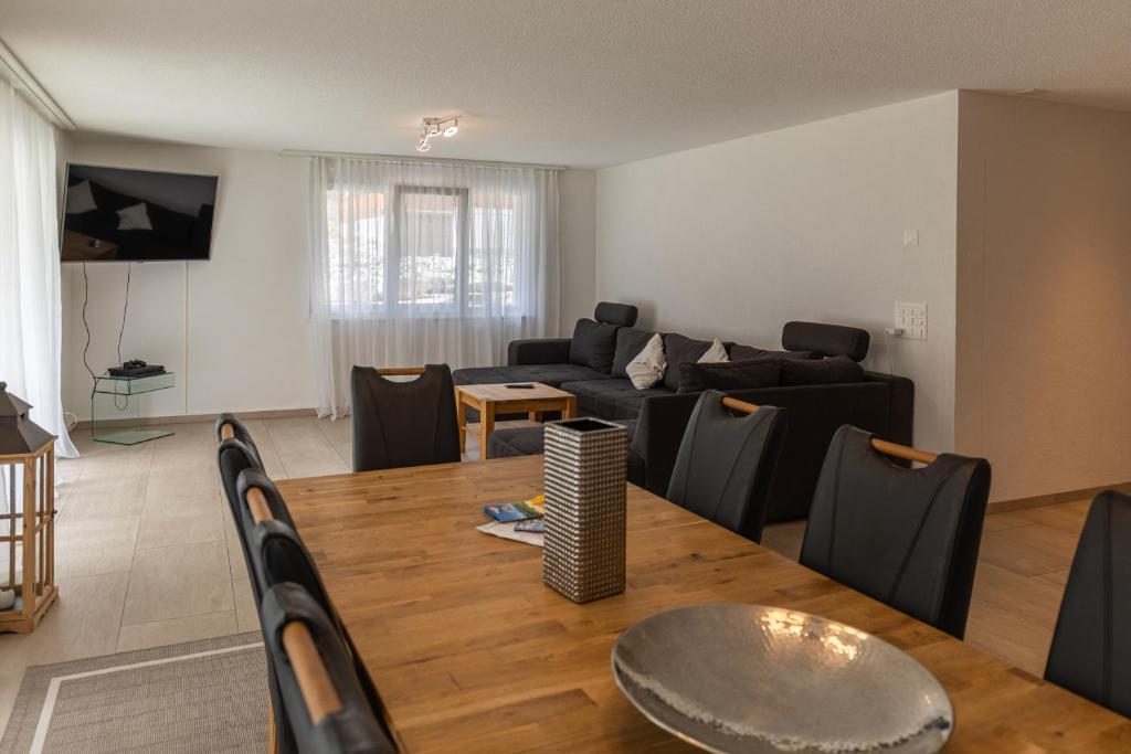 ein Wohnzimmer mit einem Tisch und einem Sofa in der Unterkunft Chalet Gousweid- Mönch Apartment in Wilderswil