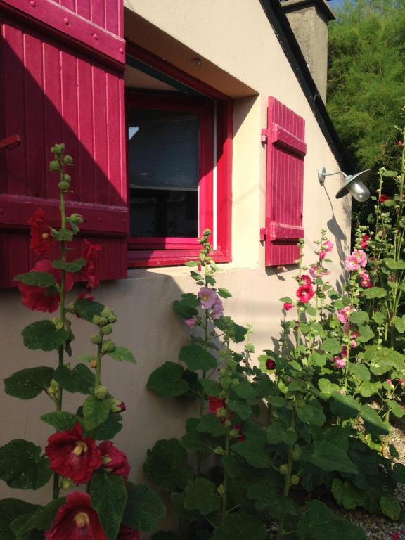 a window with red shutters on a house with flowers at Entre Mer et Marais Salants in Guérande