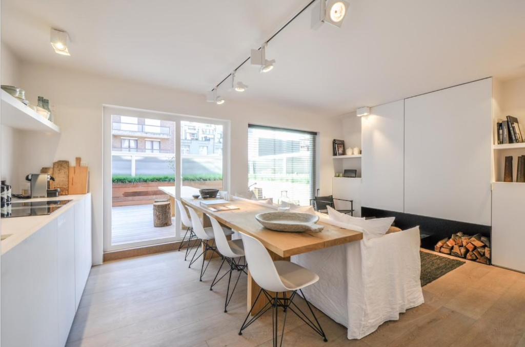a kitchen and dining room with a wooden table and chairs at Julias Stay in Knokke-Heist