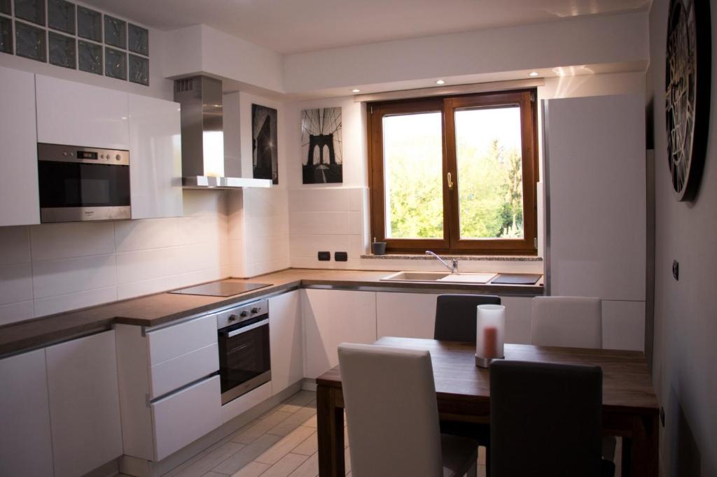 a kitchen with a table and a sink and a window at Res. Chalet a 10 min. da Rho Fiera e Stadio Meazza in Milan