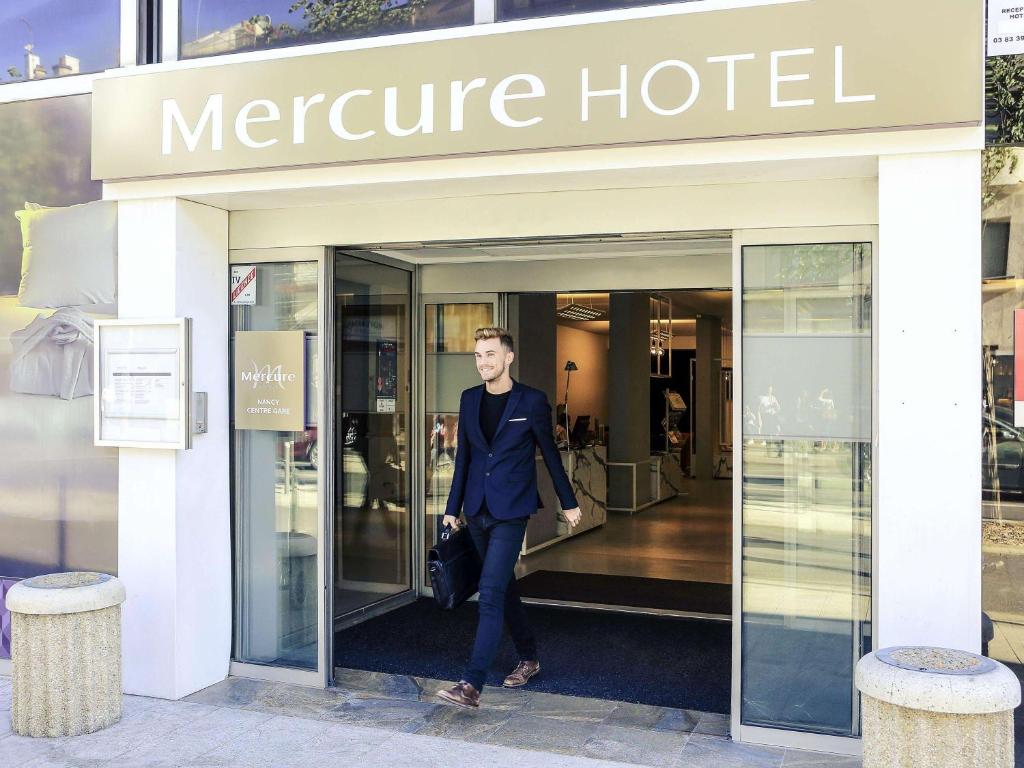 een man die een mentor hotel verlaat bij Mercure Nancy Centre Gare in Nancy