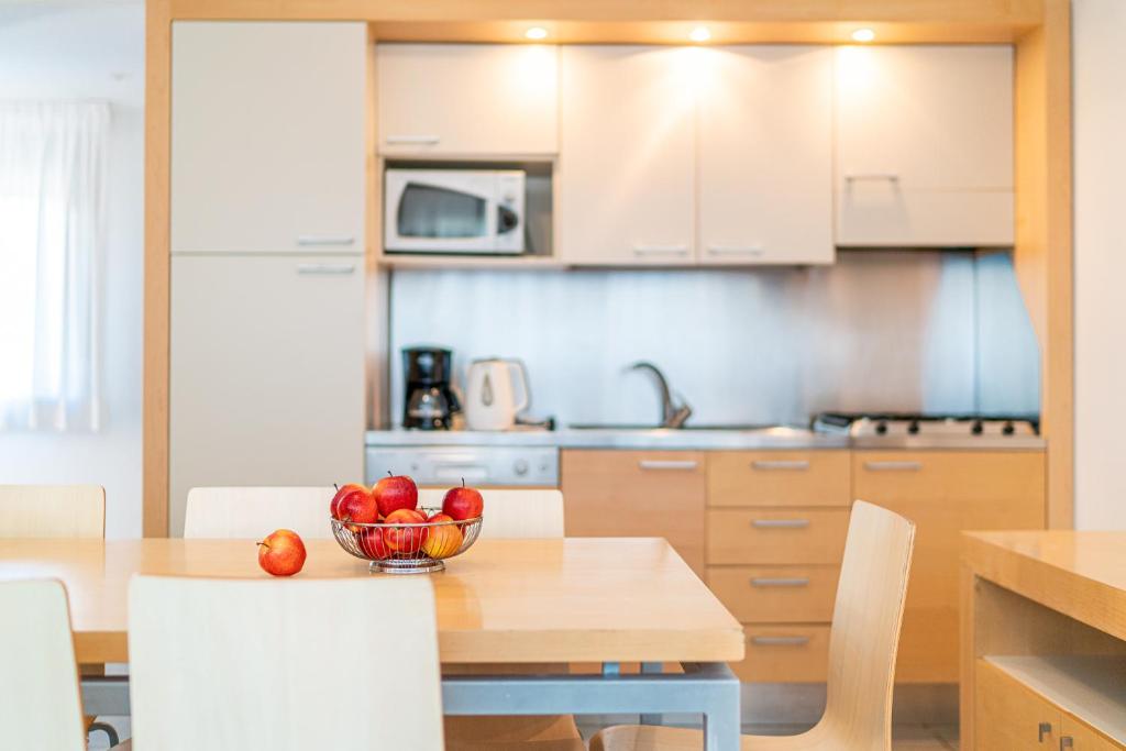 eine Küche mit einem Tisch und einer Obstschale darauf in der Unterkunft Residence AIRONE in Lignano Sabbiadoro
