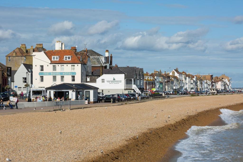 einen Strand mit Häusern und Autos drauf und das Meer in der Unterkunft Royal Hotel in Deal