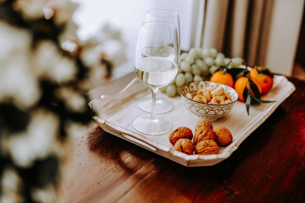 a table with a plate of fruit and a glass of wine at Dimora Anderì in Polignano a Mare