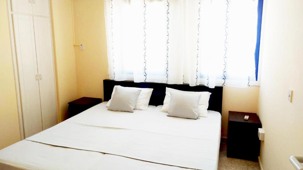 - une chambre avec un lit doté de draps blancs et une fenêtre dans l'établissement 603 Agia Napa Center, à Ayia Napa