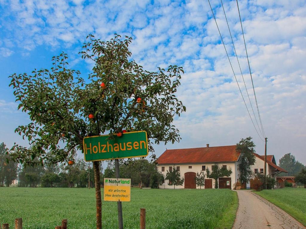 a street sign in front of a tree and a house at Holzhauser Hof in Waldkraiburg