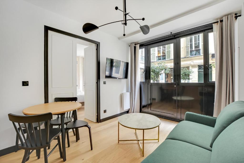 un soggiorno con divano blu e tavolo di Pick A Flat's Apartment in Opera - Rue Grange Batelière a Parigi