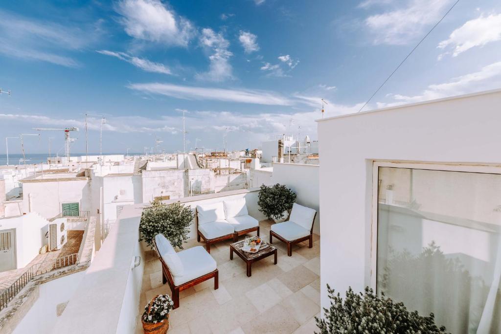 a balcony with white chairs and a view of the city at Dimora Anderì in Polignano a Mare