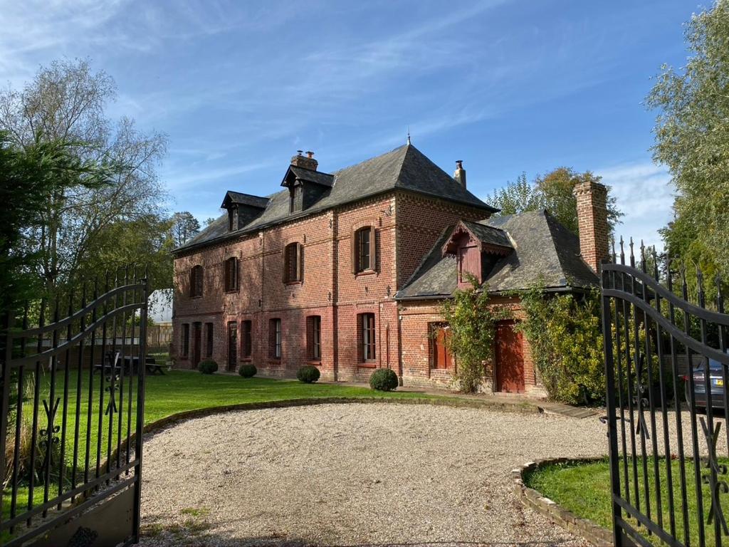 ein altes Backsteinhaus mit einem Tor davor in der Unterkunft Stunning 5 bedroom French Manor house, Normandy in Beaunay