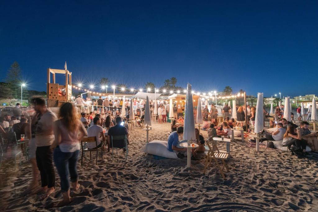 a crowd of people on a beach at night at Le Palmette Suites in Cagliari