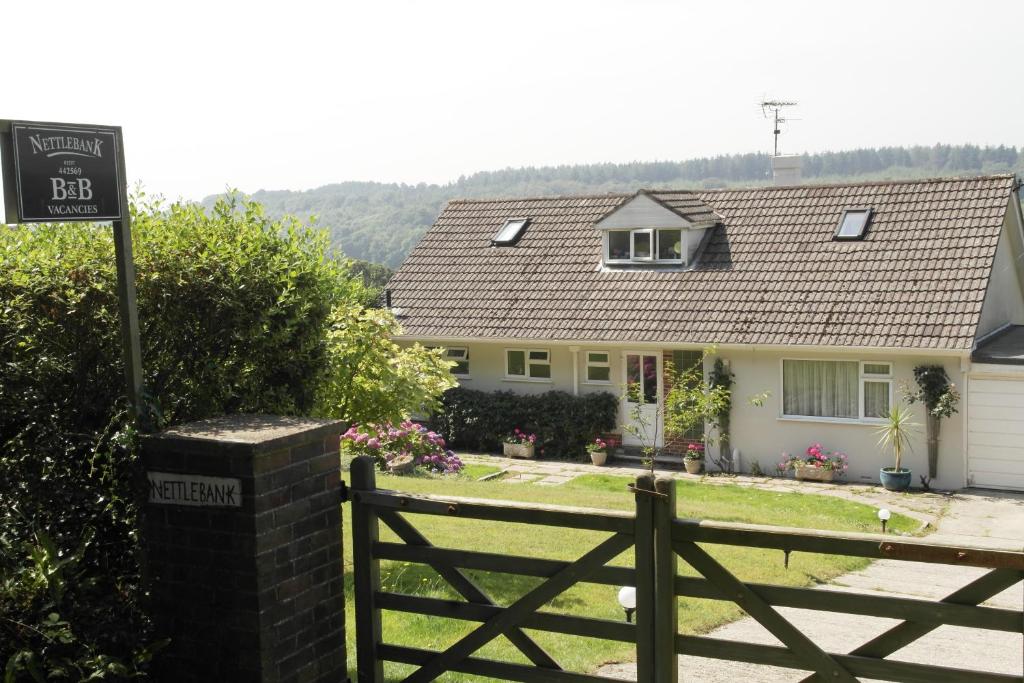 um sinal em frente a uma casa com uma cerca em Nettle Bank em Lyme Regis