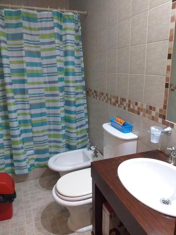 a bathroom with a toilet and two sinks and a shower at Taruca Apart in Salta