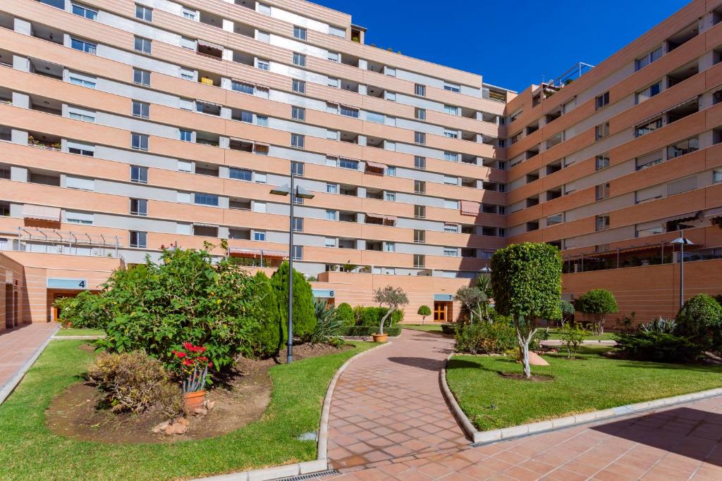 - un grand immeuble avec une passerelle devant dans l'établissement Araucaria Garden & Parking, à Malaga