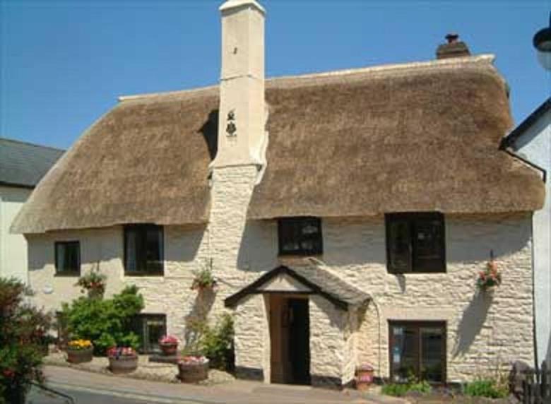 a large stone house with a thatched roof at Myrtle Cottage B&B in Porlock