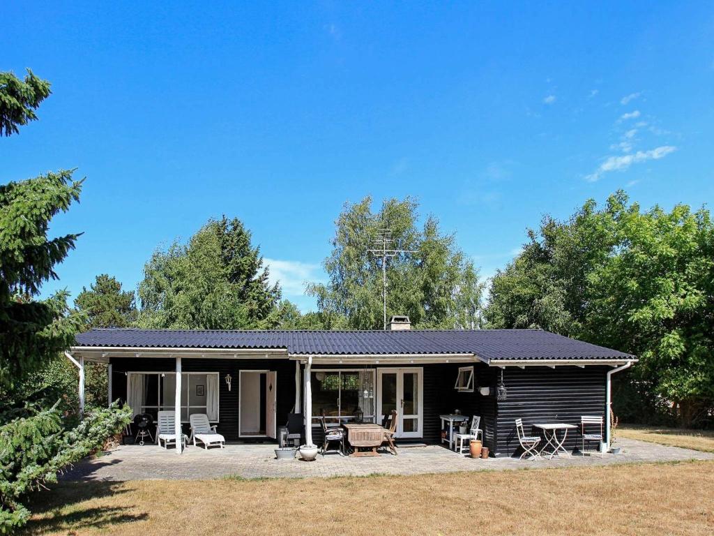 a log cabin with a porch and patio at Holiday home Asnæs VII in Asnæs