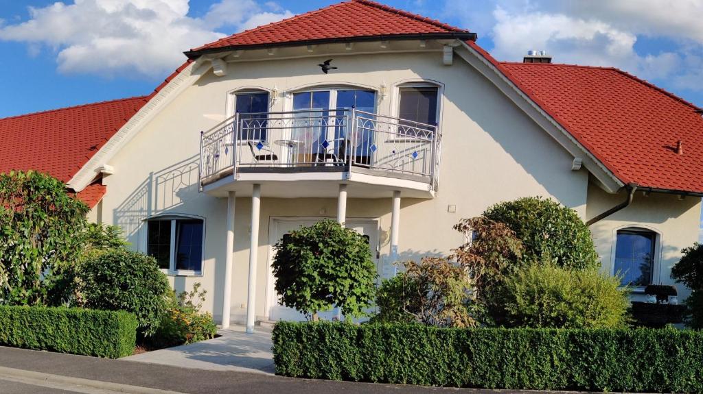 une maison blanche avec un toit rouge dans l'établissement Ferienwohnung am Hollergraben, à Oberschwarzach