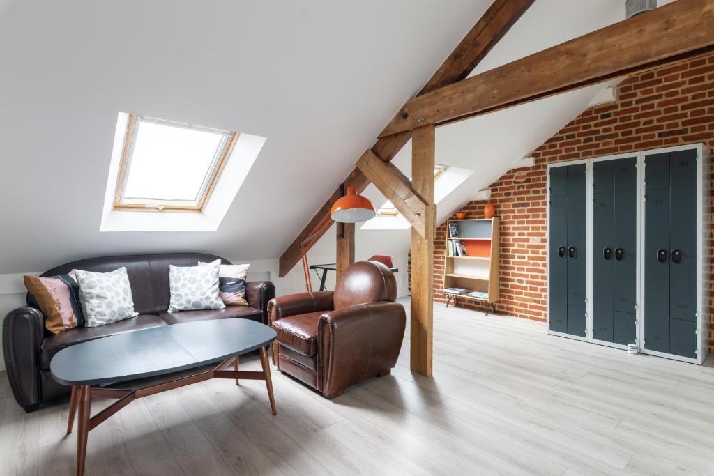 un salon avec un canapé en cuir et une table dans l'établissement L'Ao, à Rennes