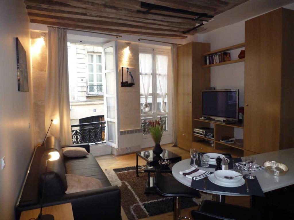 a living room with a table and a television at Gorgeous Paris St Germain des Près in Paris