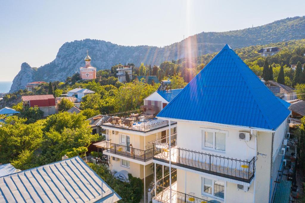 a building with a blue roof in a city at Atriy Hotel in Simeiz