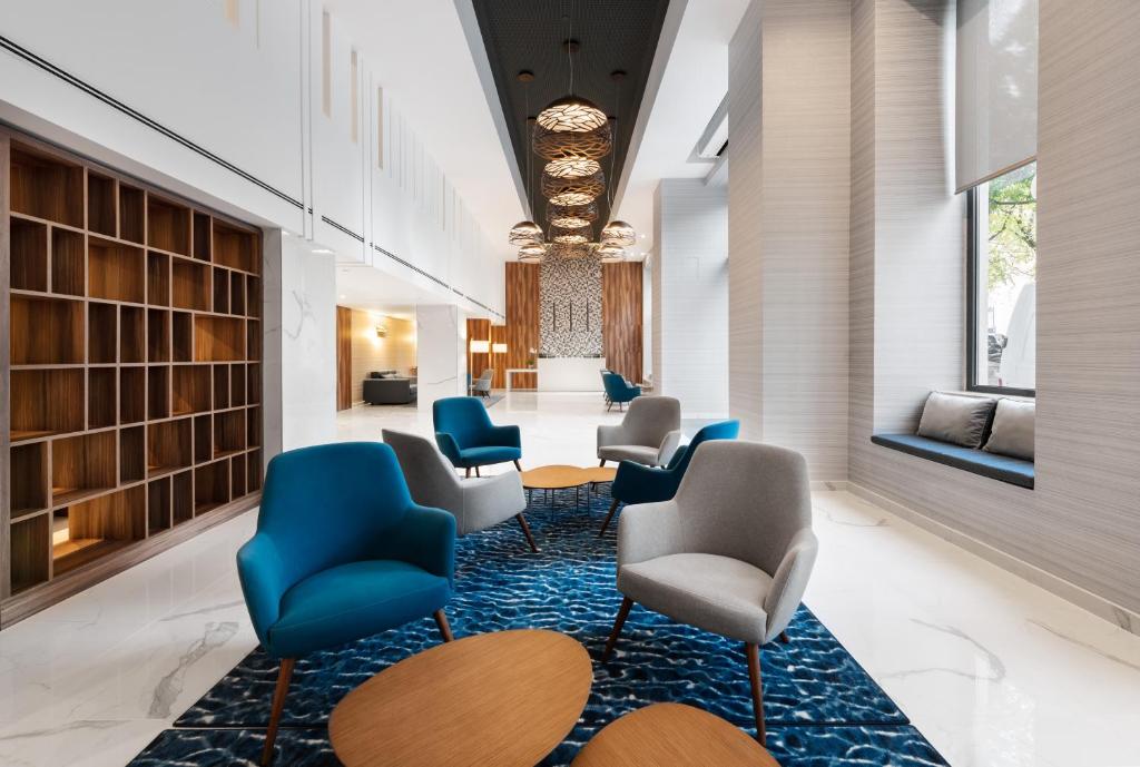 A long lobby lounge lined with armchairs, tables and a window seat.
