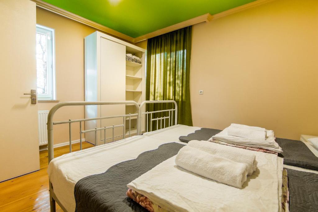 a bed in a room with a green ceiling at Guest House Bolnisi - Colorful Apartment in Bolnisi