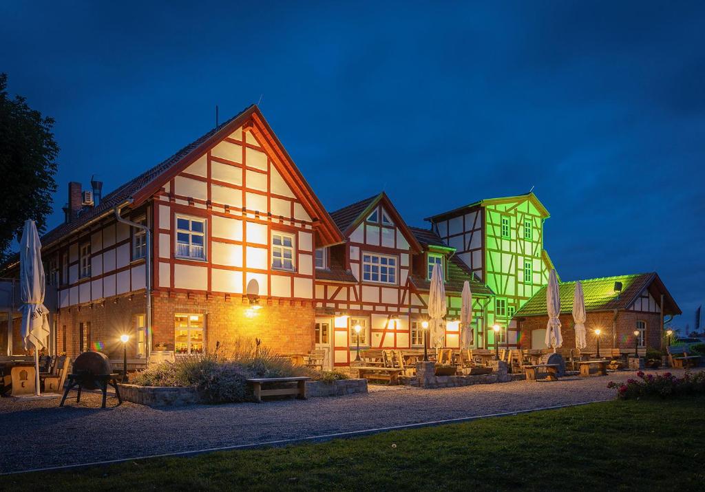 um grande edifício é iluminado à noite em Hotel Restaurant Mühlenhof Bosse em Dachwig