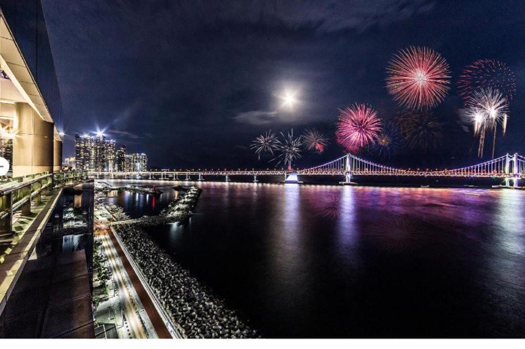 a fireworks display over a river with a bridge at H Avenue Hotel Gwangalli branch in Busan
