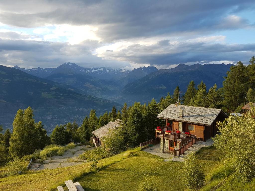 a house on a hill with mountains in the background at Chalet D'Antan in Pila