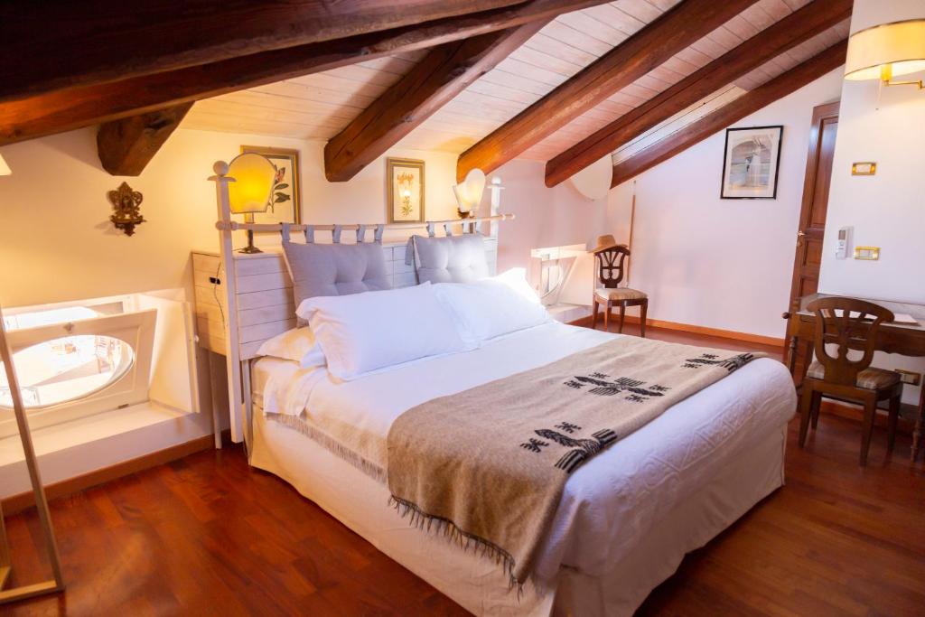 um quarto com uma cama grande e uma banheira em Palazzo Sismonda em Corneliano d'Alba