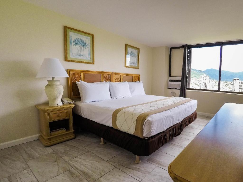 a hotel room with a bed and a window at Waikiki Monarch Hotel in Honolulu