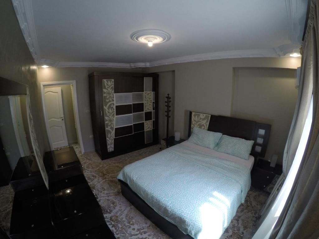 a bedroom with a large bed in a room at Al Hamed for Furnished Apartments in Cairo