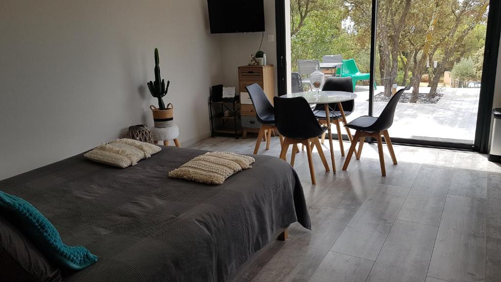 a bedroom with a bed and a table and chairs at gite A L' ÉVIDENCE in Mornas