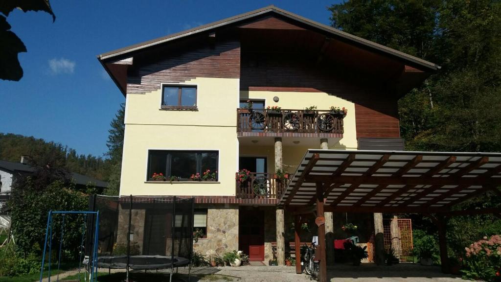 a house with a balcony on top of it at Appartment Bezenica in Dobrova