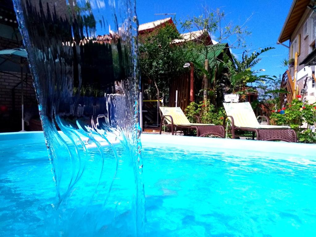 una fuente en medio de una piscina en Recanto dos Bambus Pousada en Florianópolis