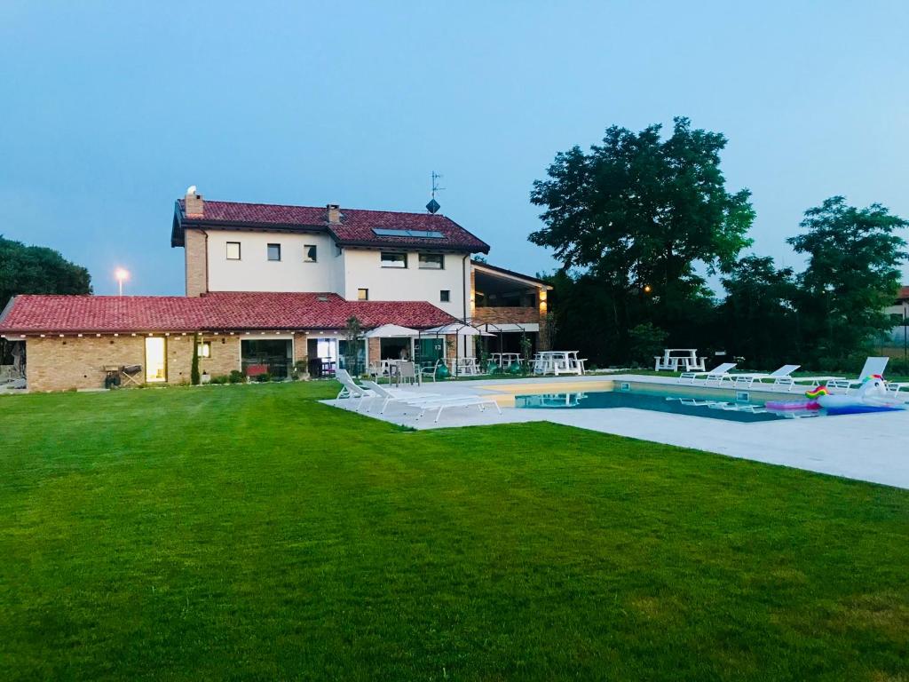 une grande maison avec une piscine dans la cour dans l'établissement B&B La Corte Dei Vizi, à Clauiano