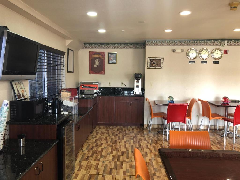 a living room with a kitchen and a table with chairs at Executive Inn westley,CA in Westley