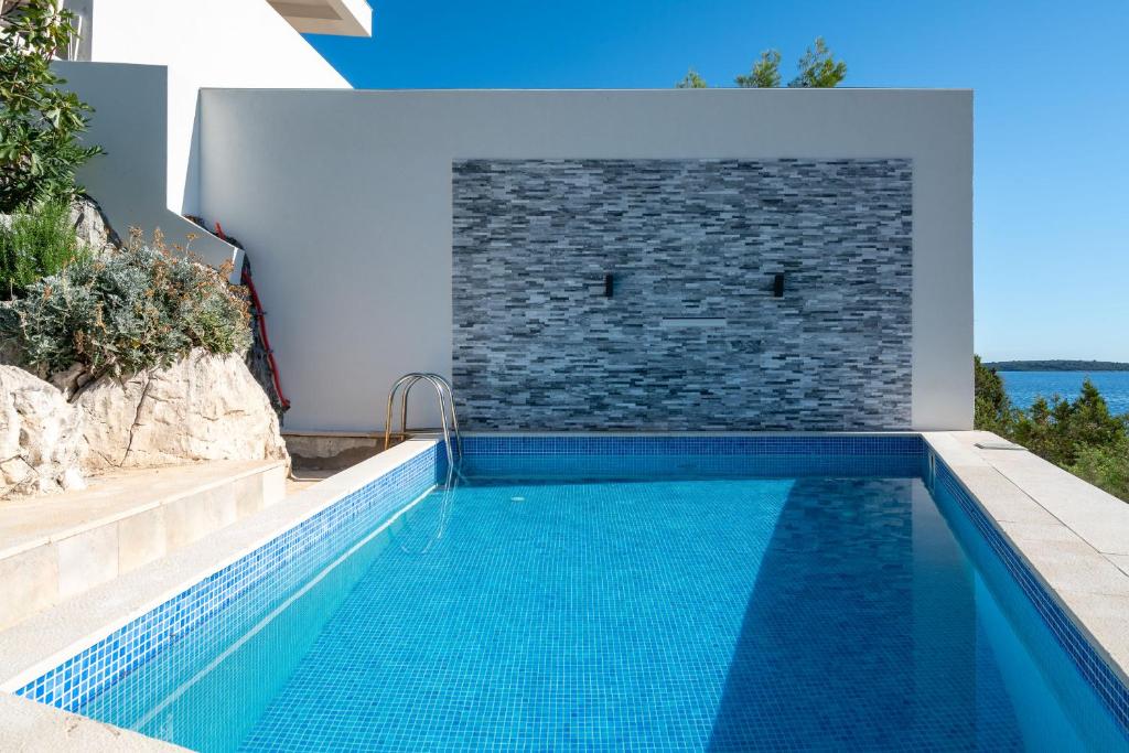 a swimming pool in a backyard with a stone wall and a swimming pool at Villa Sine in Sevid