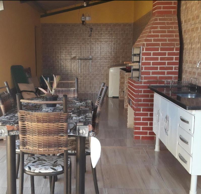 cocina con mesa, sillas y pared de ladrillo en Casa de Sufia, en Alto Paraíso de Goiás