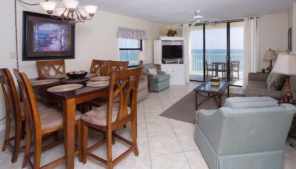 ein Esszimmer und ein Wohnzimmer mit einem Tisch und Stühlen in der Unterkunft Sunswept 601 Condo in Orange Beach