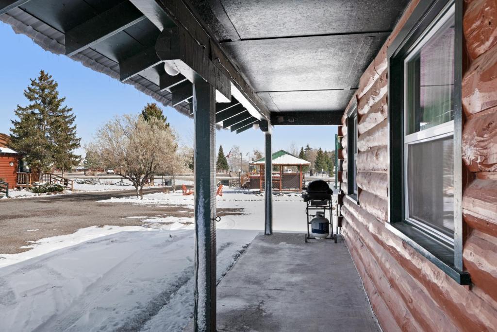 a covered porch of a house with snow on the ground at Foothills Lodge and Cabins in South Fork