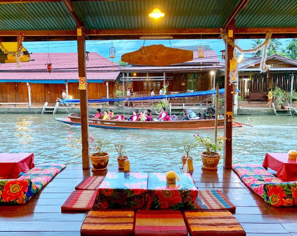 a group of people riding a boat in the water at Baanklong Amphawa Homestay in Amphawa