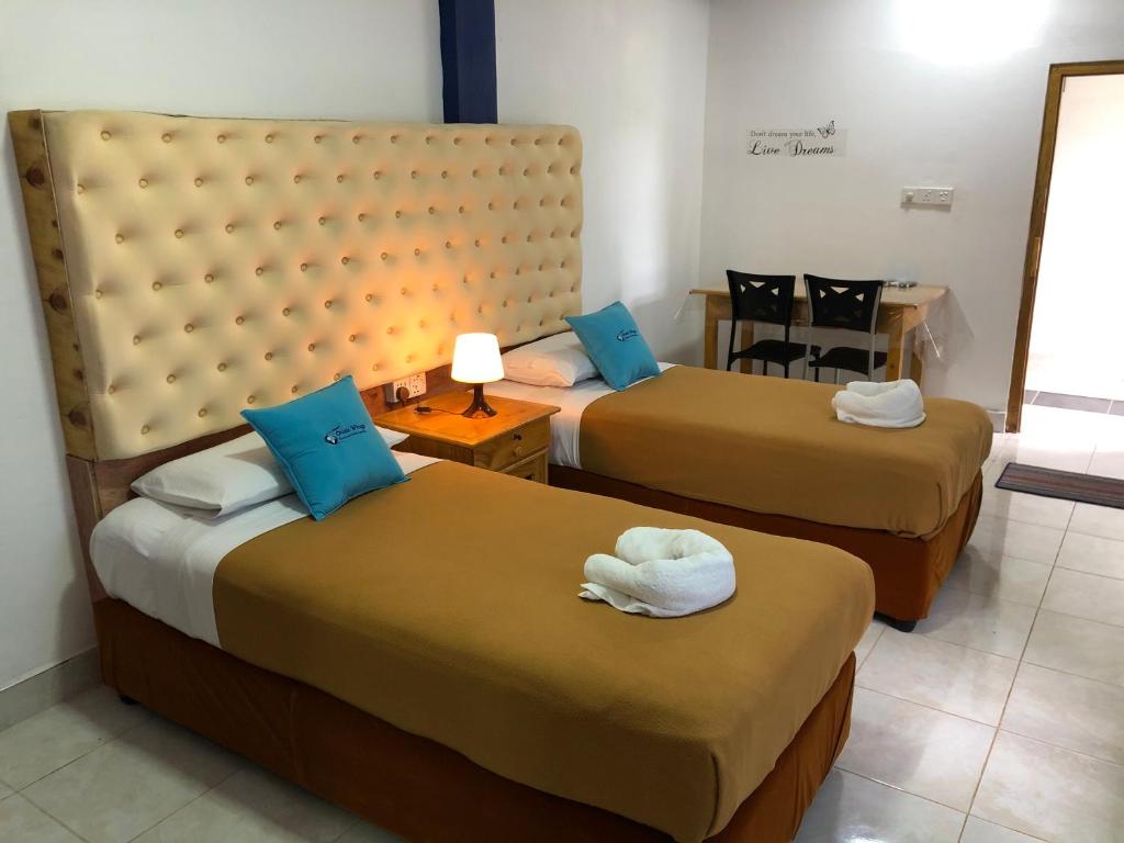 a hotel room with two beds with towels on them at Oasis Wings Hotel in Mannar