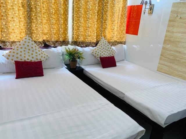 two twin beds in a room with yellow curtains at Woodstock Hostel in Hong Kong