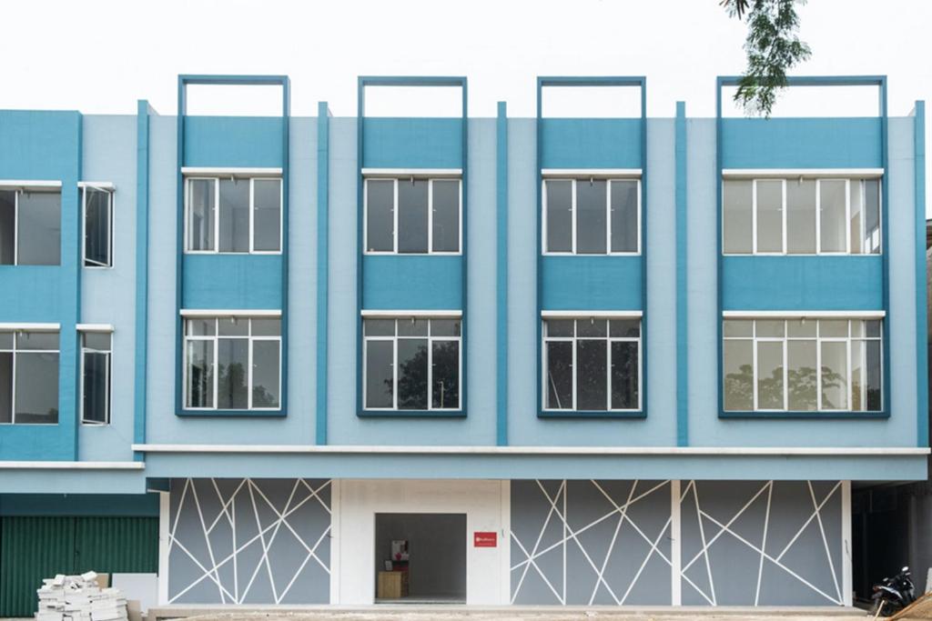 a blue building with white windows at RedDoorz Plus @ Otista Raya Ciputat in Tangerang
