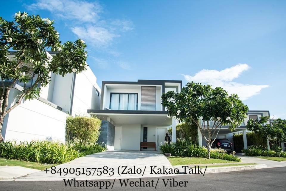 a large white house with trees in front of it at Clean & Quiet Villa - The Point Resort in Danang