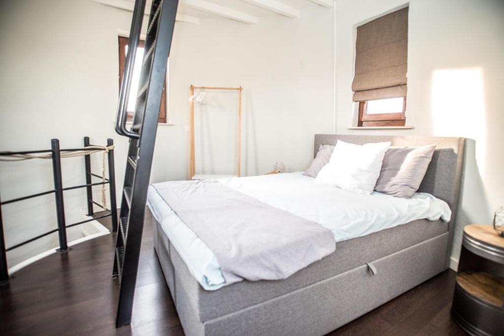 een bed met witte lakens en kussens in een kamer bij De Lievensmolen in Damme