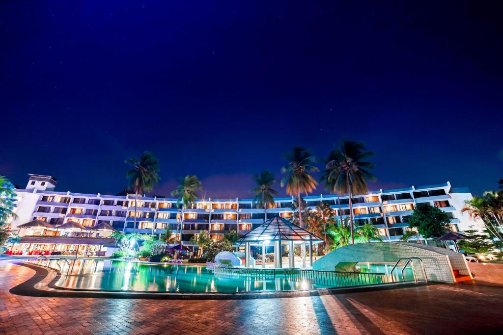 un hotel de noche con palmeras en el fondo en Tunamaya Beach & Spa Resort- Desaru, en Desaru